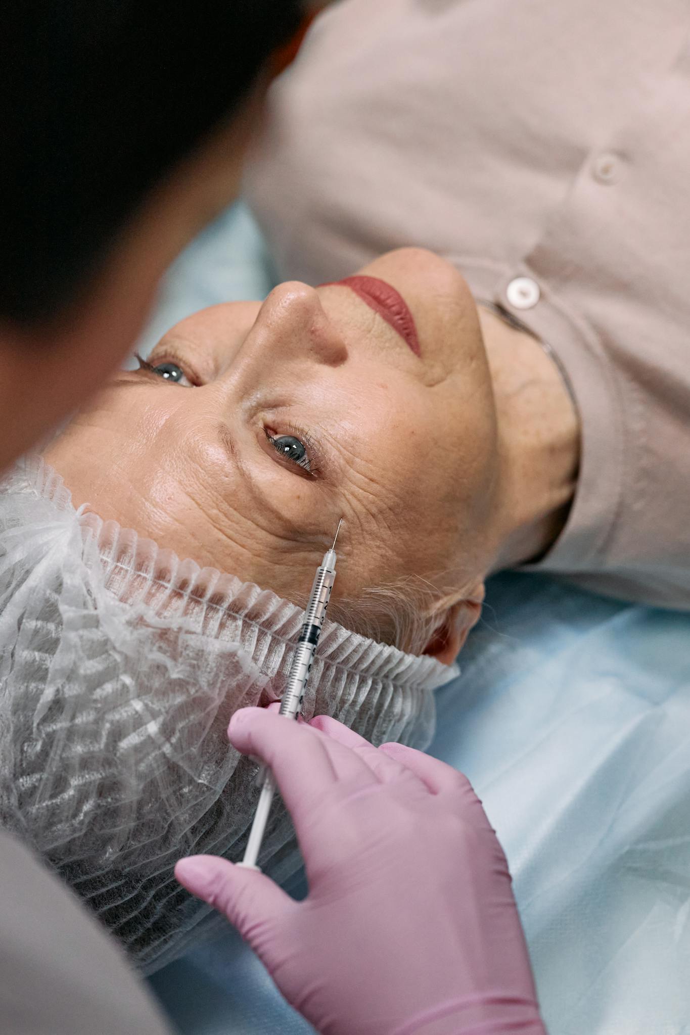 Close-up of a senior woman receiving a cosmetic injection treatment.